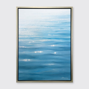 A blue, white and teal abstract seascape print in a silver floater frame hangs on a white wall.