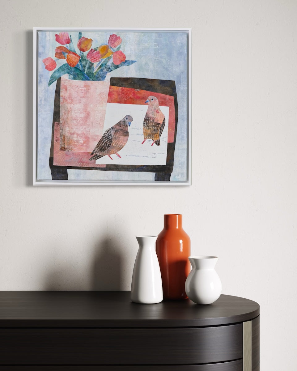 A framed square collage hanging on a light wall above a dark cabinet, with three ceramic vases on the cabinet. The painting depicts two birds in front of a pink and red screen-like shape, with orange and pink flowers at the top.