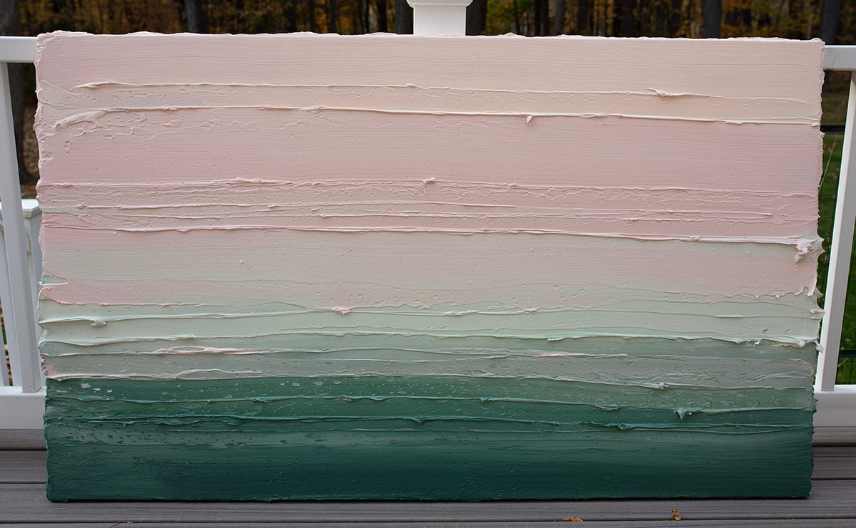 A light Coral, light pink, celadon and hunter green thickly textured abstract painting by Teodora Guererra leaning outside on a deck.