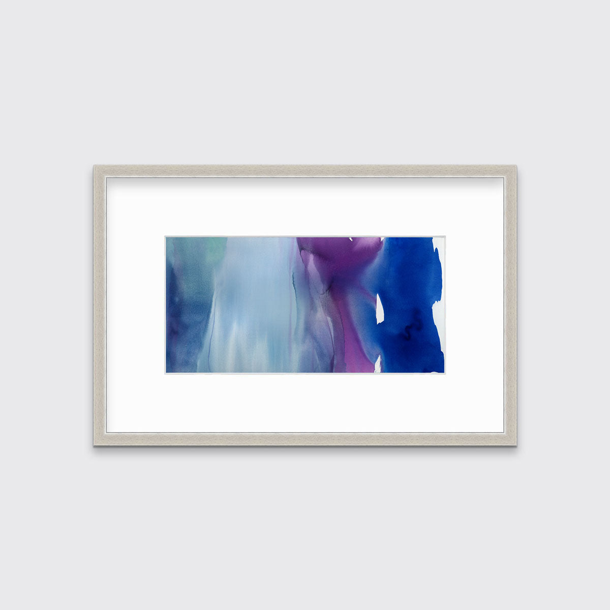A blue, purple and white abstract print in a silver frame with a mat hangs on a white wall.