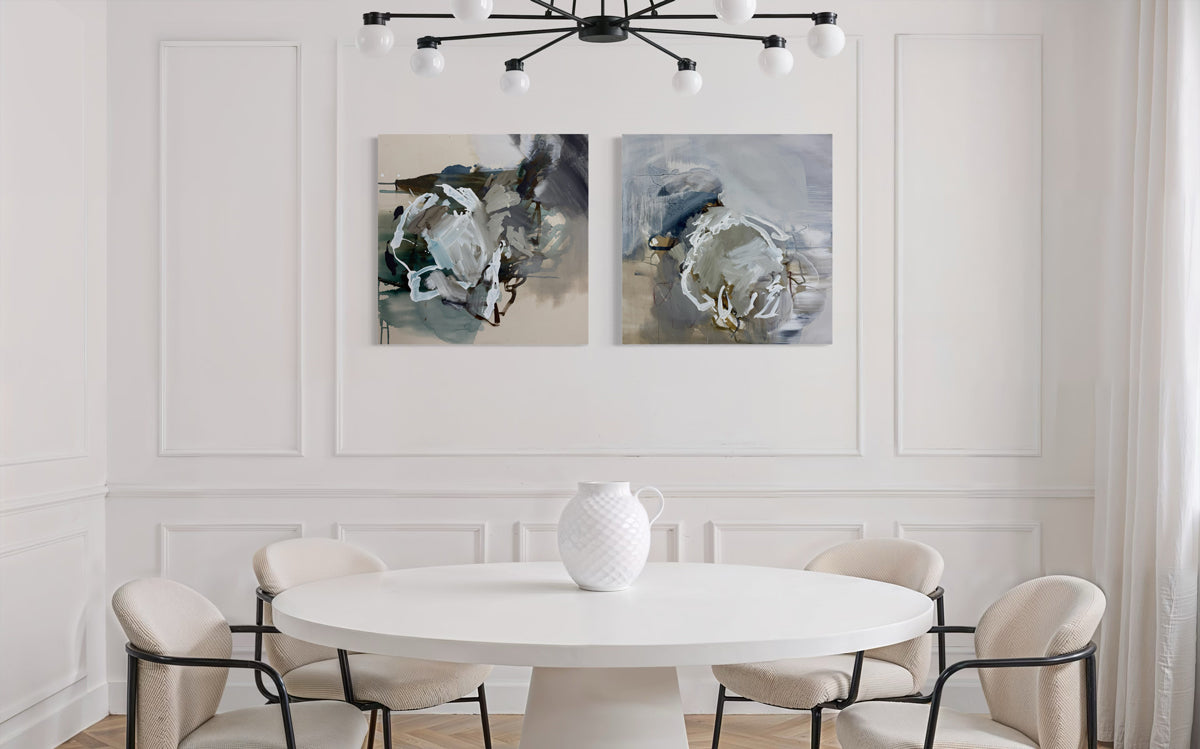 Modern dining room with a white round table and chairs, abstract paintings on the wall.