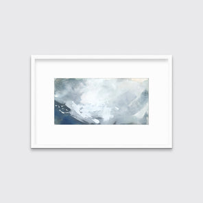 A blue, grey and white abstract print in a white frame with a mat hangs on a white wall.