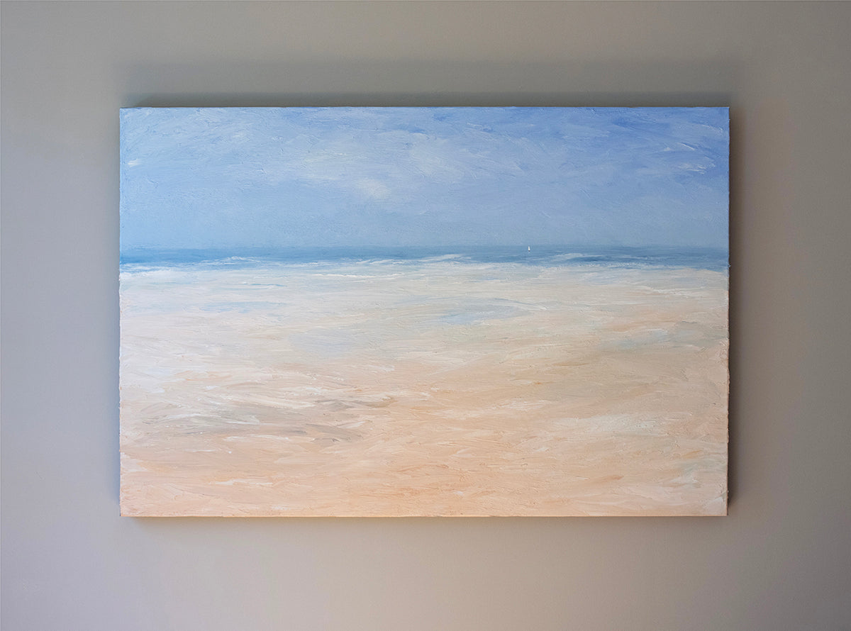 An abstracted coastal seascape painting hangs on a grey wall.