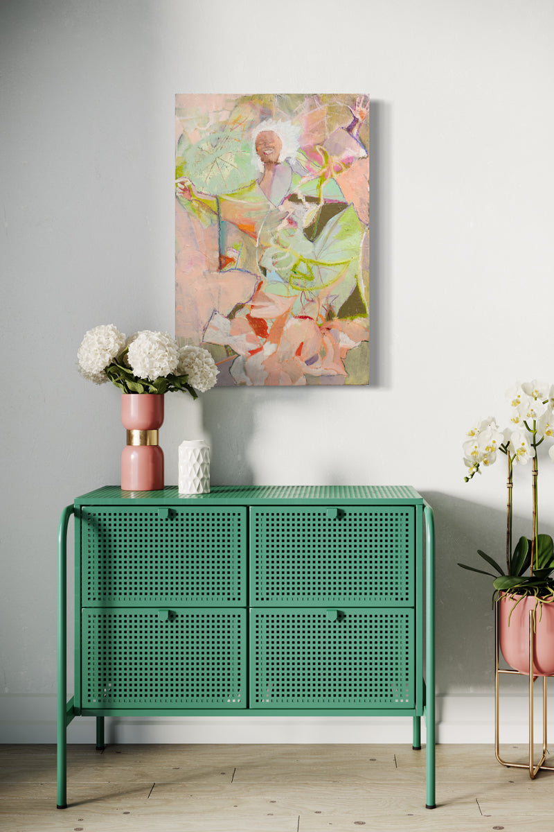 A pink abstracted figure painting hangs on a white wall above a metal green console table with pink and white table decor and floral arrangements.