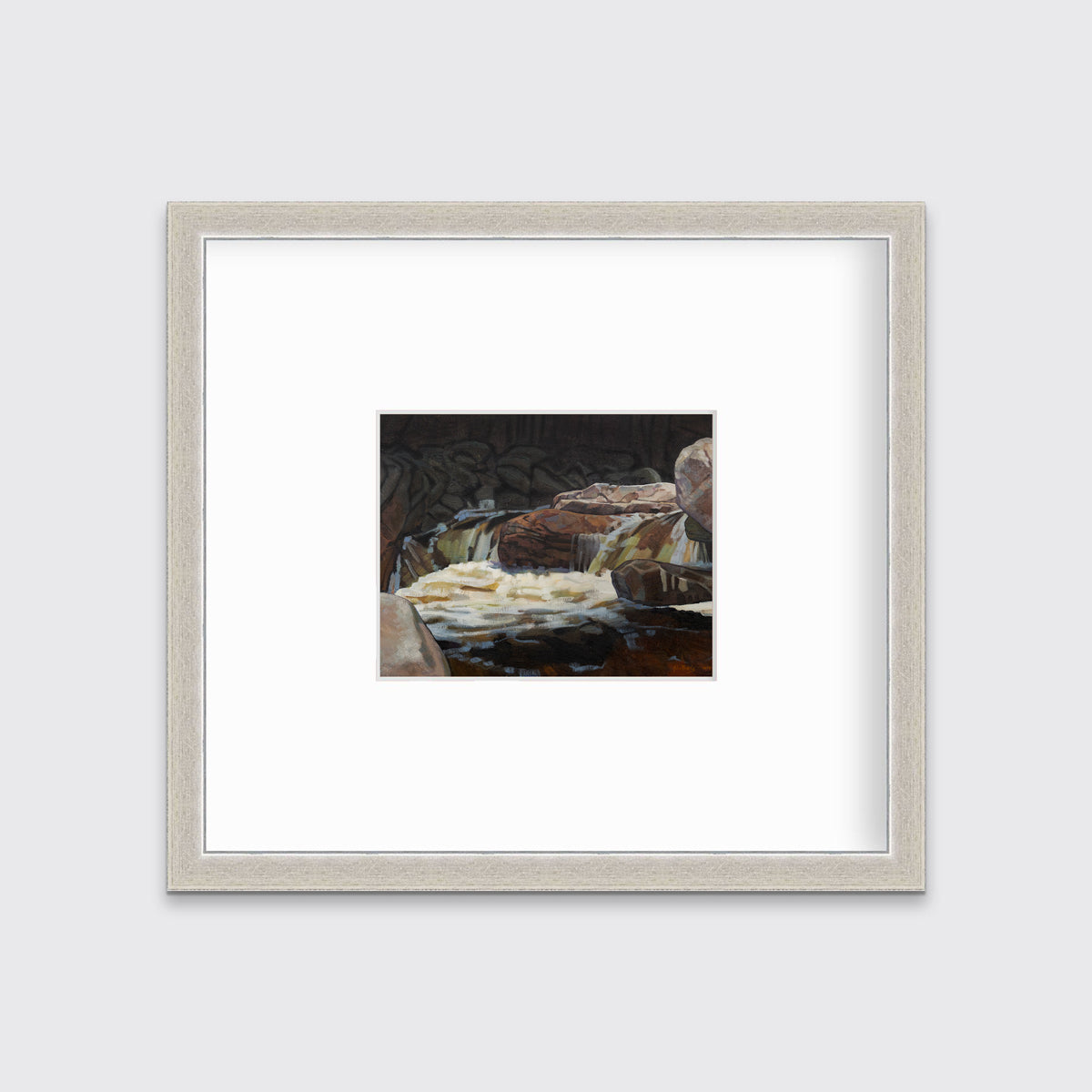A brown, black and white abstract river landscape print in a silver frame with a mat hangs on a white wall.