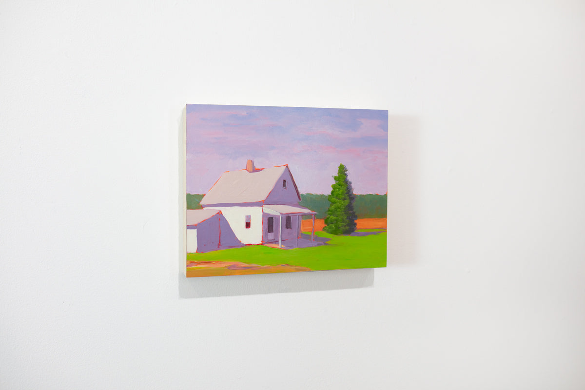 A small purple, green, and orange landscape painting hangs on a white wall.