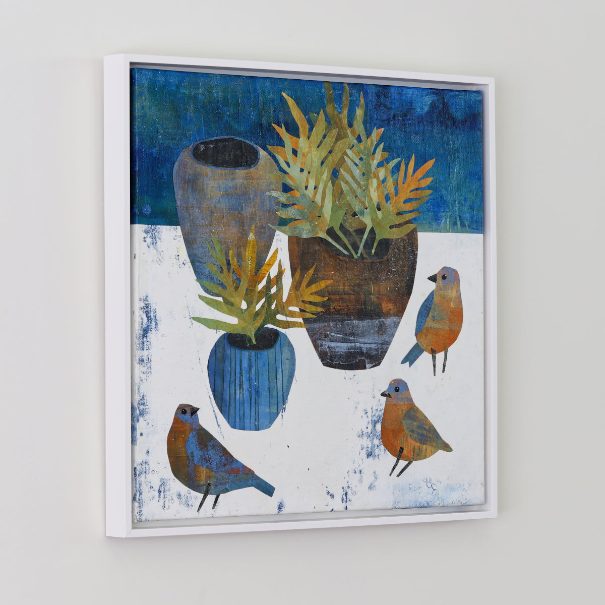 A framed collage featuring a still life painting with blue and green plants in rustic vases and four small birds, displayed on a light gray wall.