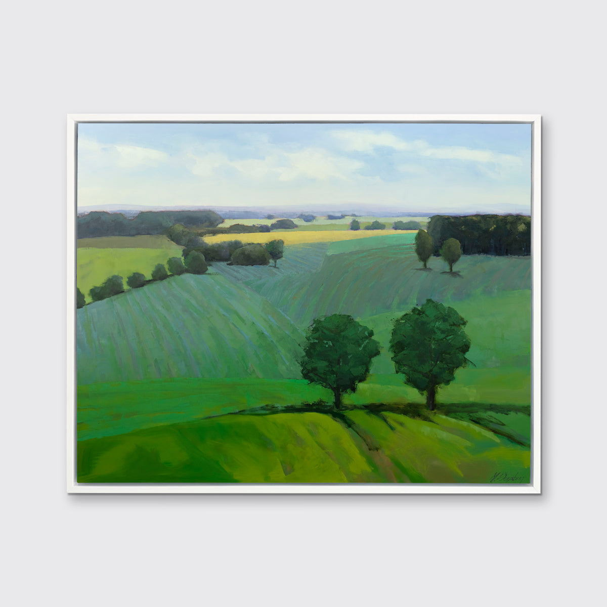 A landscape print in a white floater frame hangs on a white wall.