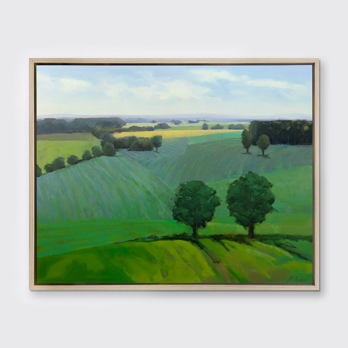 A landscape print in a white oak wood floater frame hangs on a white wall.