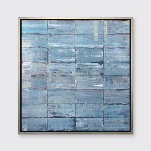 An abstract blue-green limited edition art print by Ned Martin framed in a silver frame hangs on a white wall.
