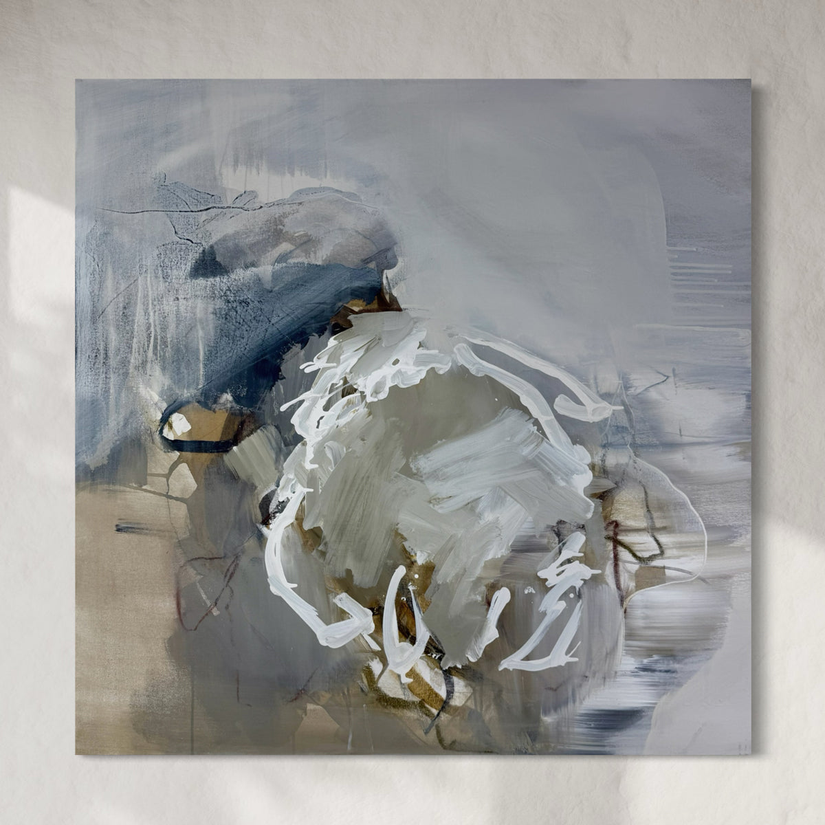 Abstract painting with swirling brushstrokes in white, blue, and beige on a textured wall.