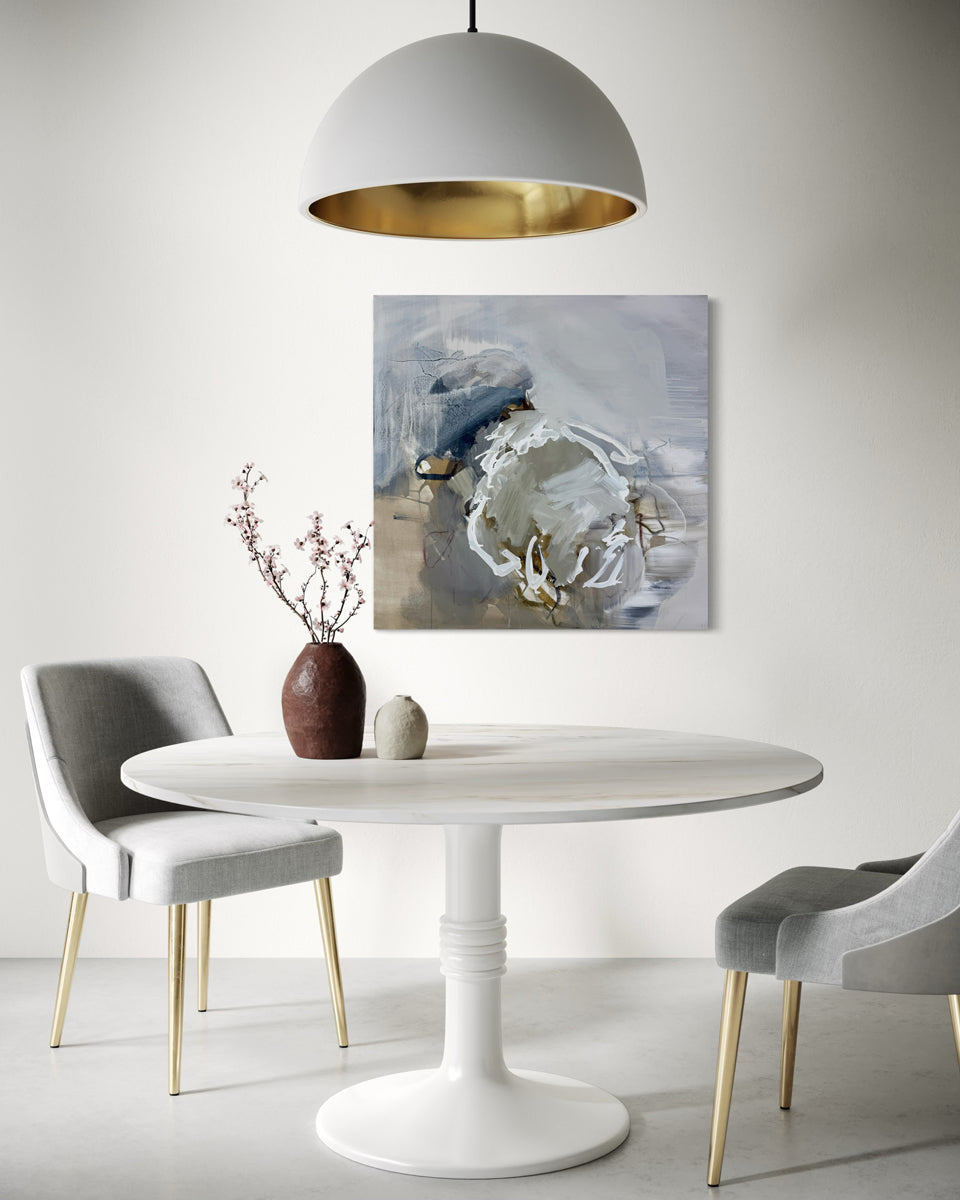 Modern dining room with a white round table, gray chairs, and abstract artwork on the wall.