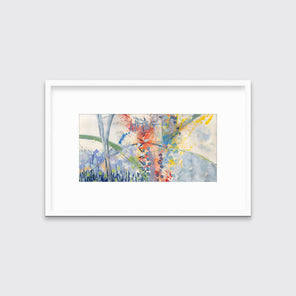 A multicolored abstract print in a white frame with a mat hangs on a white wall.
