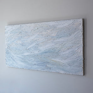 A white and light blue abstract painting with thick, impasto brushstrokes is seen at an angle on a gallery wall.