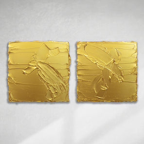 A pair of golden textured paintings by Teodora Guererra hanging on a gallery wall.