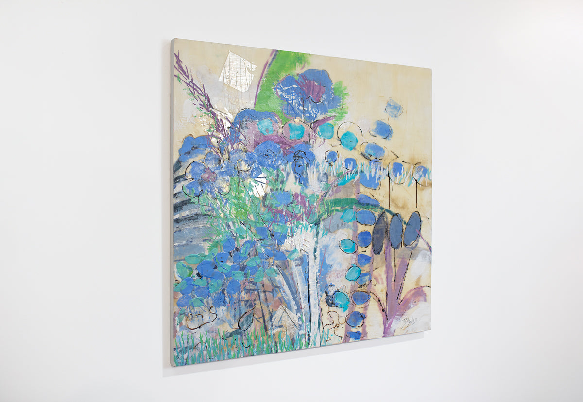 A blue and green abstracted encaustic painting hangs on a white wall.
