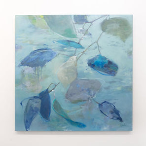 A blue abstract floral painting hangs on a white wall. 