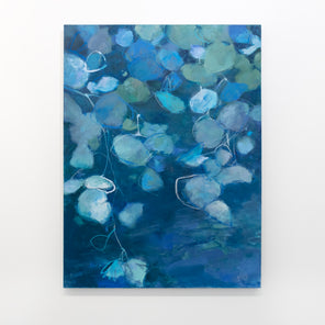 A blue abstract floral painting hangs on a white wall. 