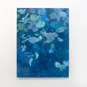 A blue abstract floral painting hangs on a white wall. 