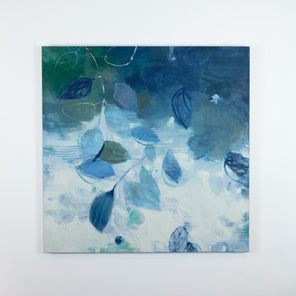 An abstract blue and white floral painting hangs on a white wall.