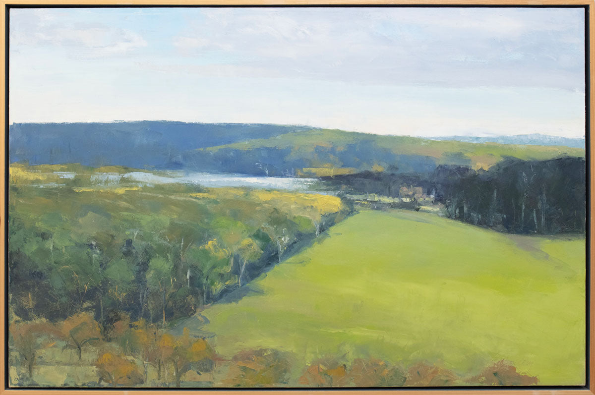 A yellow-green landscape painting in a light wood frame.