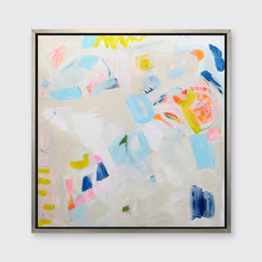 A beige, blue, yellow and orange abstract print in a silver floater frame hangs on a white wall.