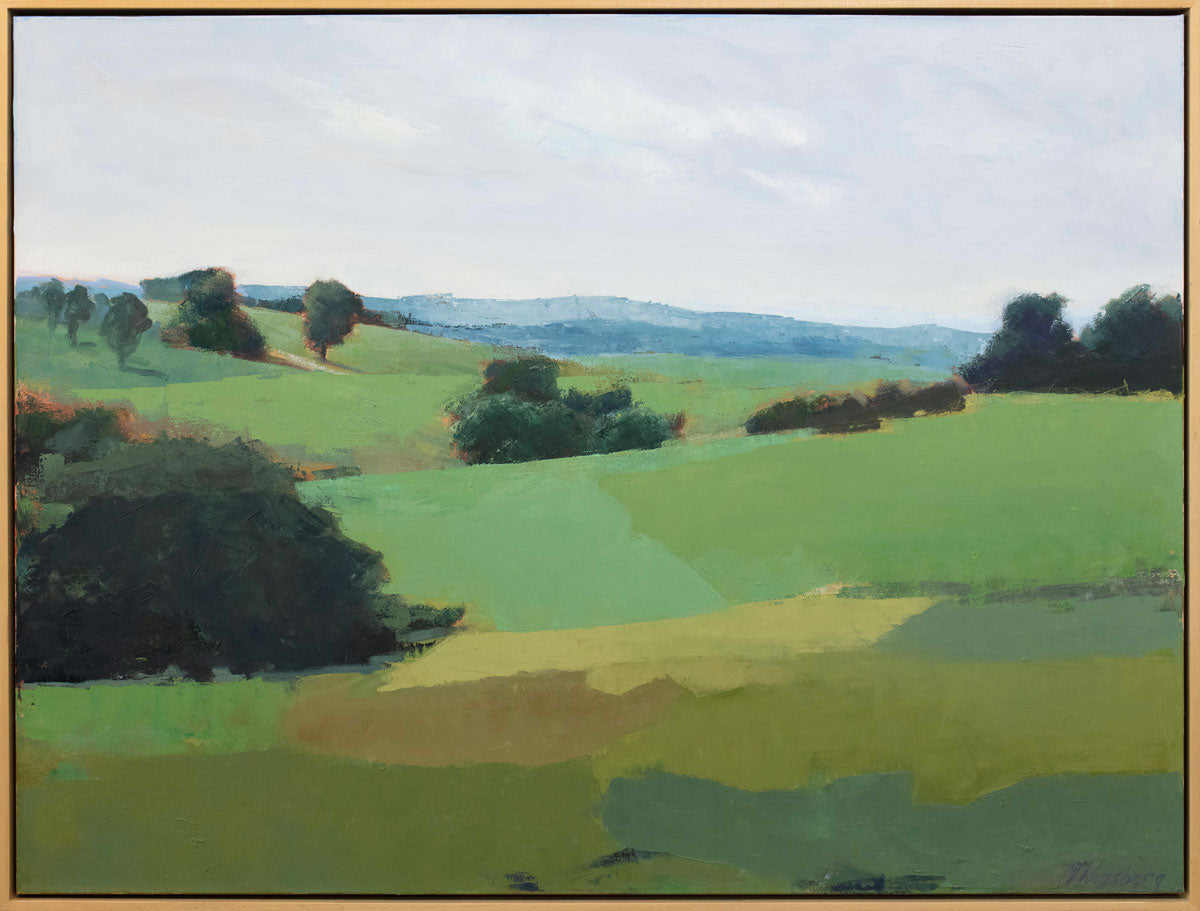A green landscape painting framed in a light wood floater frame.