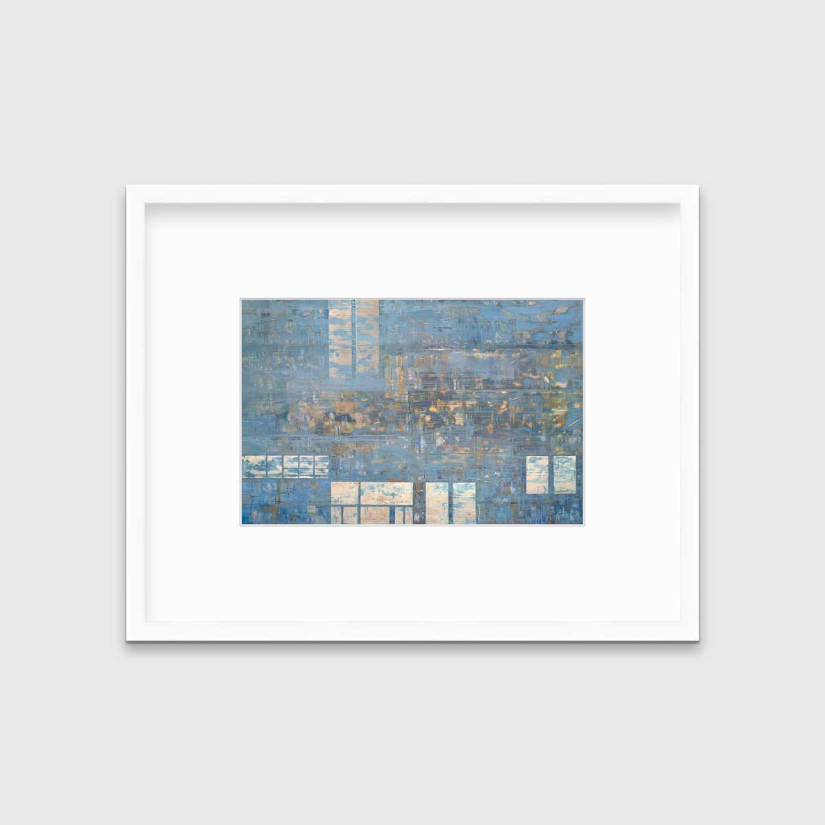 A blue and grey geometric abstract print in a white frame with a mat hangs on a white wall.