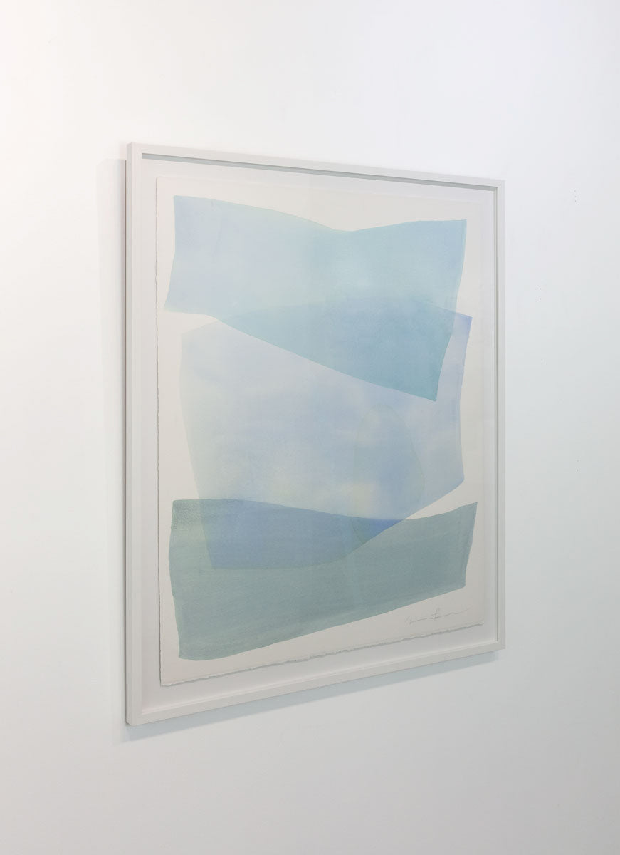 A watercolor painting of blue and turquoise stacked forms painted by Nealy Hauschildt is seen at an angle on a gallery wall.