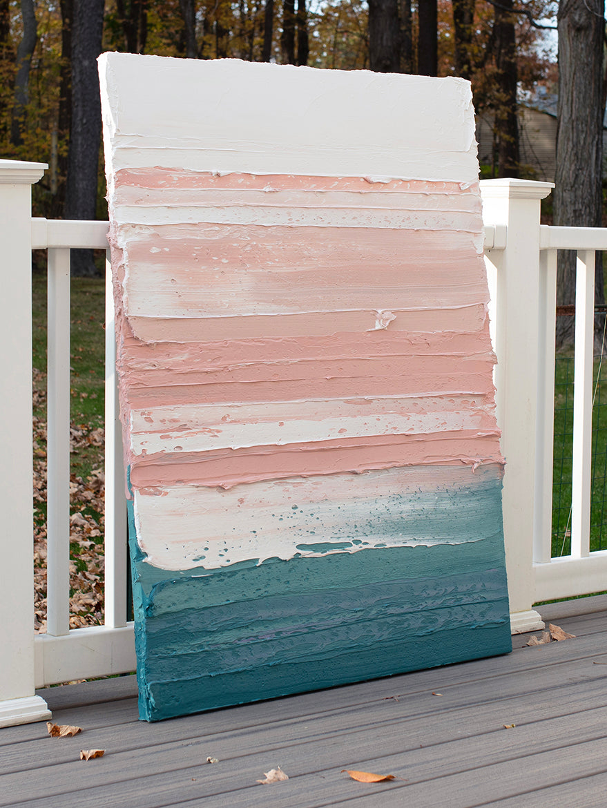 A peach, coral, white and teal with lavender thick textured painting leaning outside on a deck in natural light by Teodora Guererra.