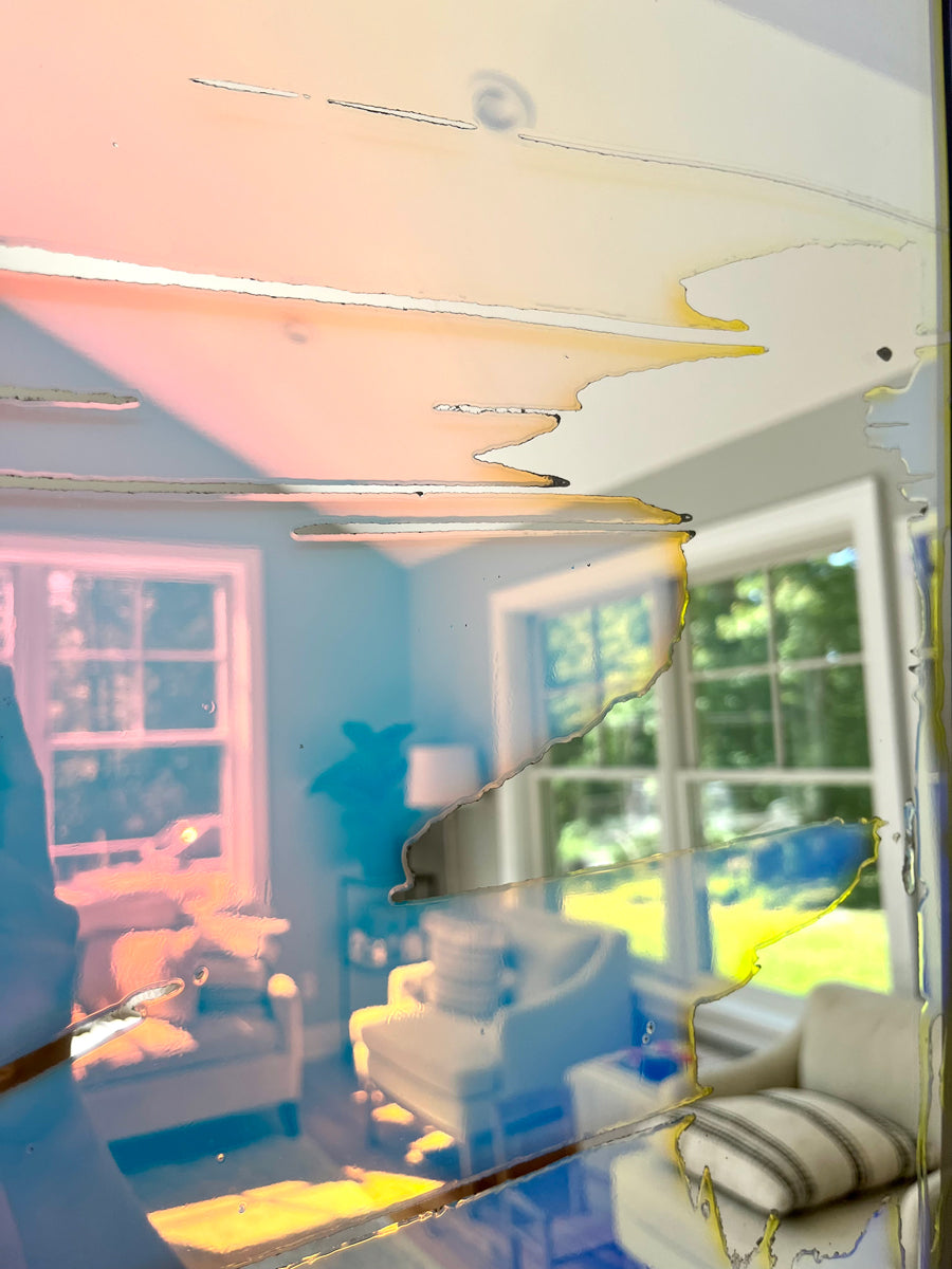 A detail of a fine art mirror reflecting the room it is in. 