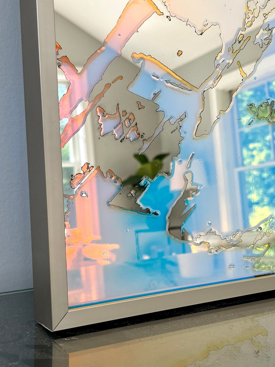 A detail of the corner of a framed fine art mirror reflecting the room it is in.