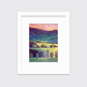 A multicolored landscape print in a white frame with a mat hangs on a white wall.