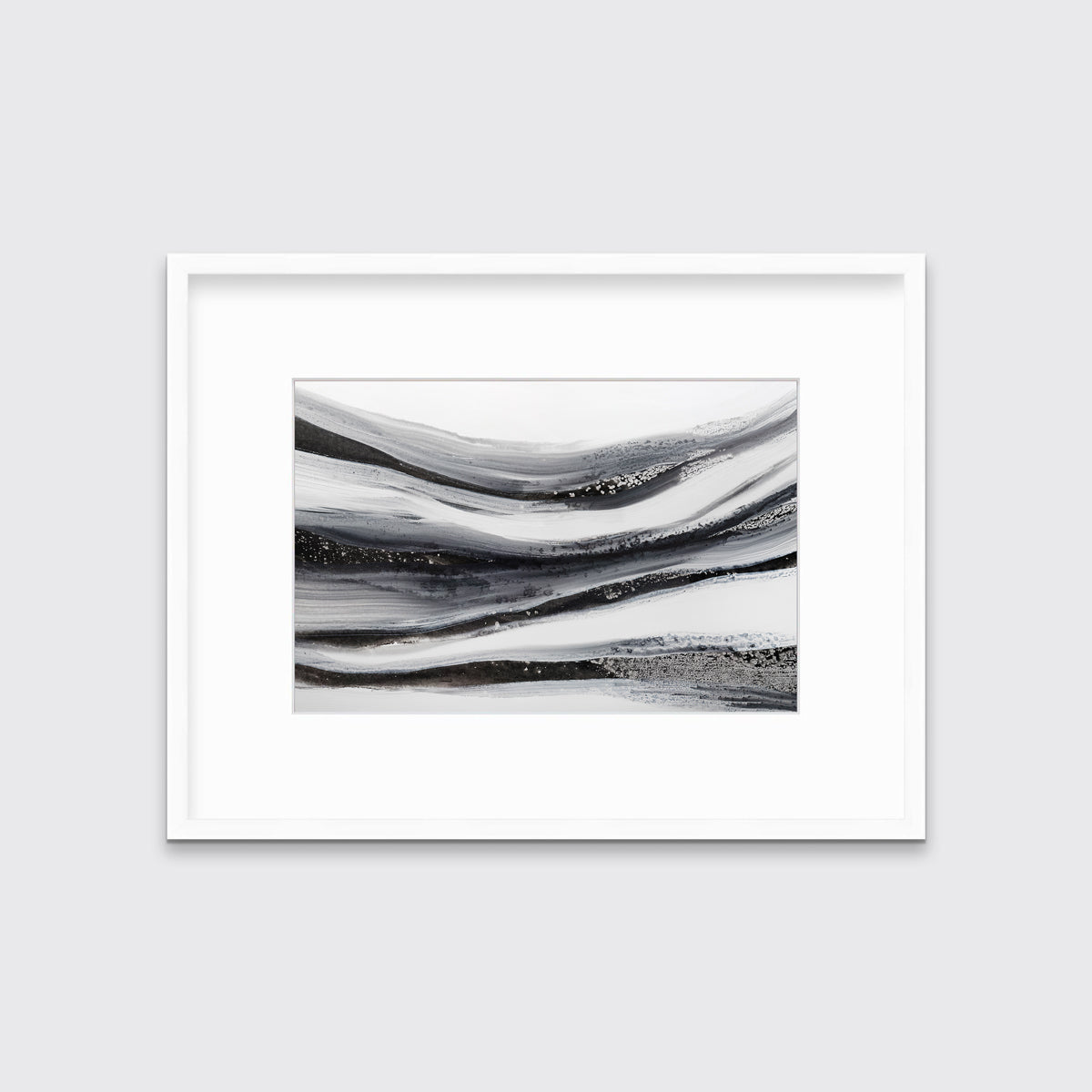 A black, white and grey abstract print in a white frame with a mat hangs on a white wall.