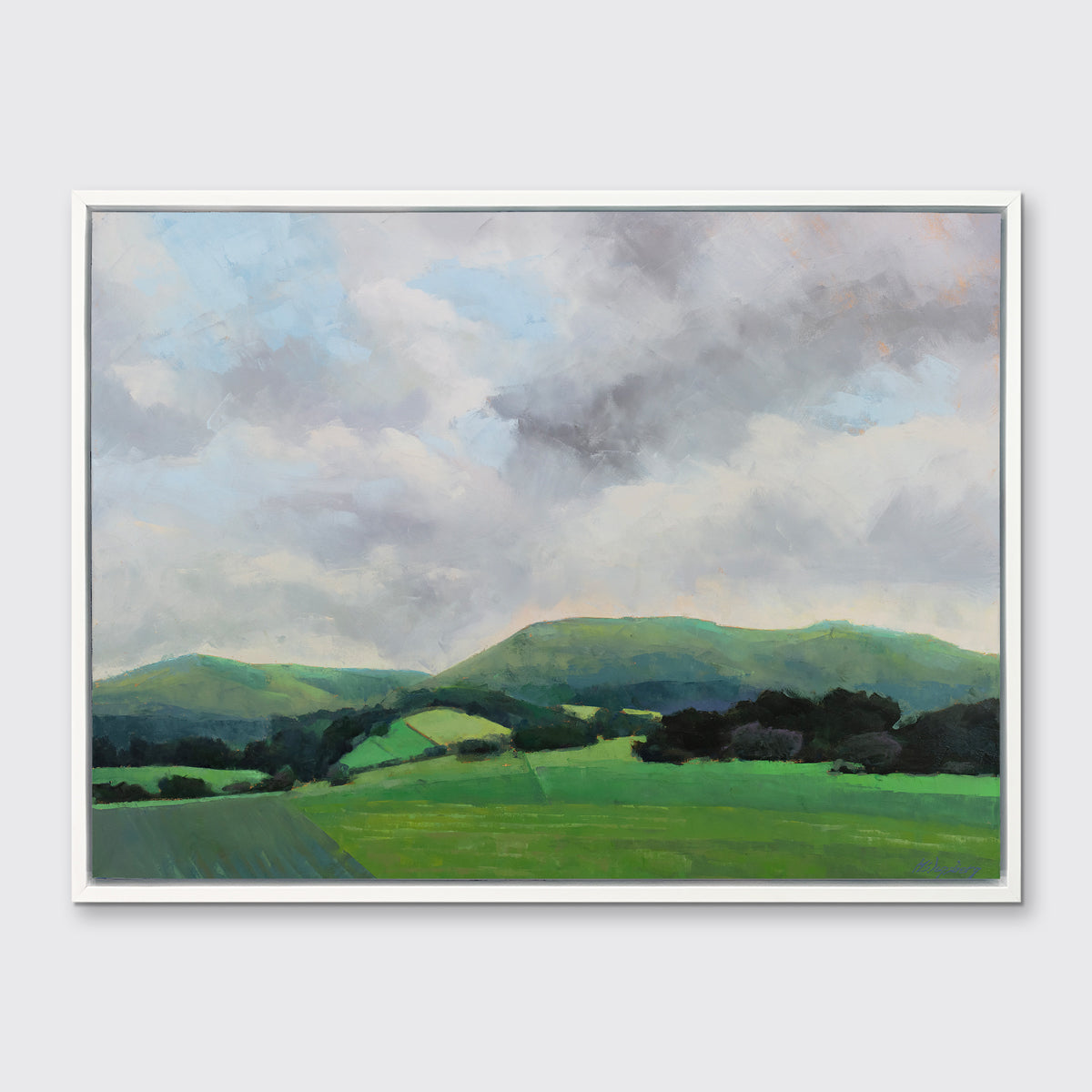 A landscape print in a white floater frame hangs on a white wall.