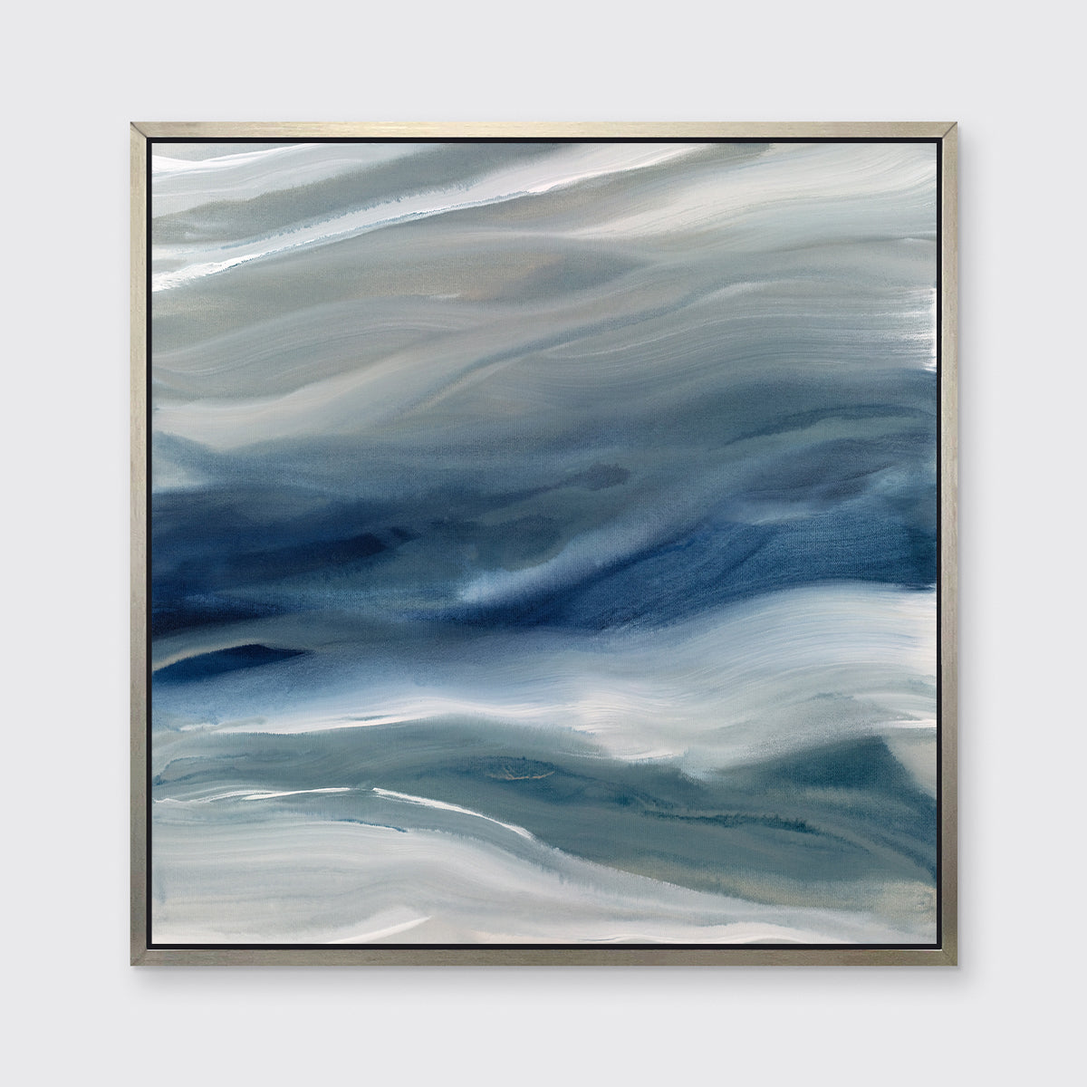 A blue, teal, beige and white abstract print in a silver floater frame hangs on a white wall.