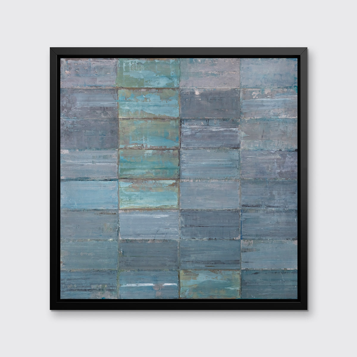 An abstract geometric slate blue and sea foam green limited edition art print by Ned Martin framed in a black frame hangs on a grey wall.