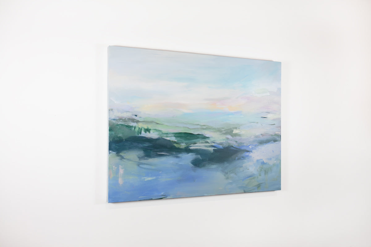 A blue, pink, and green abstract painting hangs on a white wall.