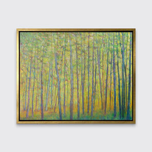 A green and yellow impressionist landscape print in a gold floater frame hangs on a white wall.