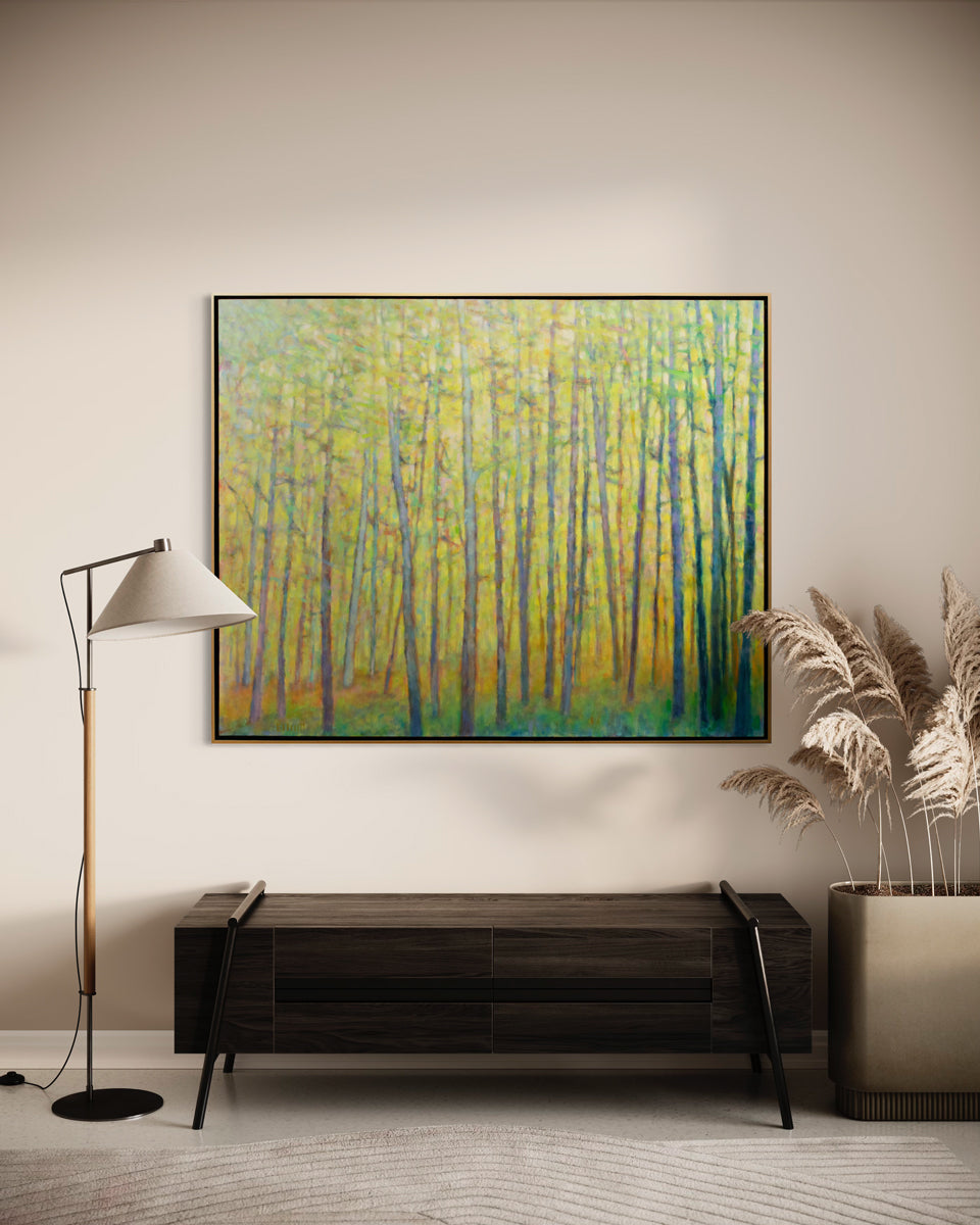 An abstracted yellow painting of forest trees hangs on a beige wall above a dark wood modern bench with a floor lamp on one side and a potted plant on the other. 