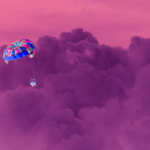 A contemporary photograph of people paragliding over a purple cloud in a pink sky by Peter Mendelson. 