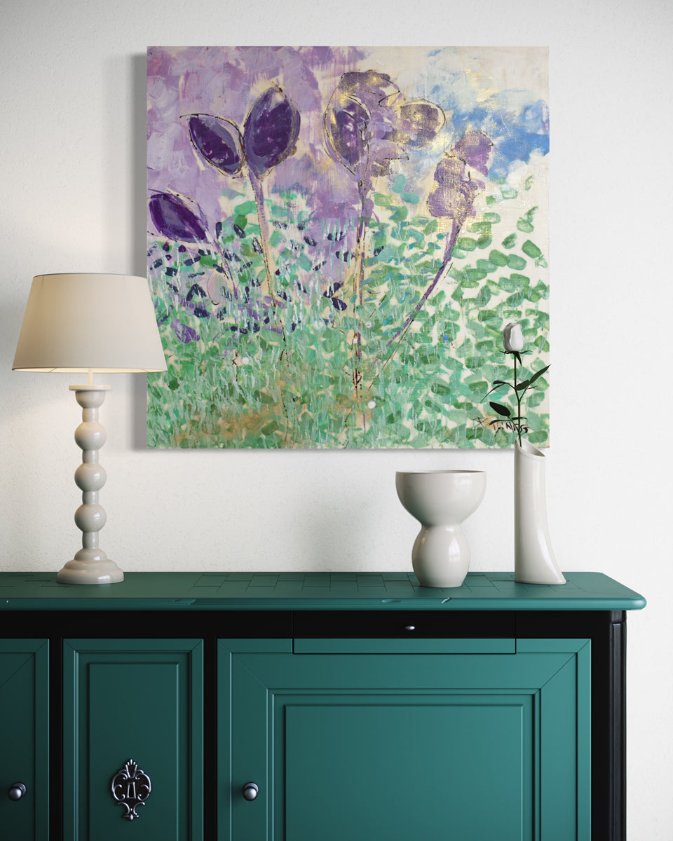 A green, blue, and violet abstracted floral painting hangs on a white wall above a deep teal console table with white ceramic table decor and a white table lamp. 