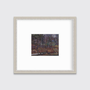 A brown, grey and green abstract landscape print in a silver frame with a mat hangs on a white wall.