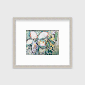 An abstract floral print in a silver frame with a mat hangs on a white wall.