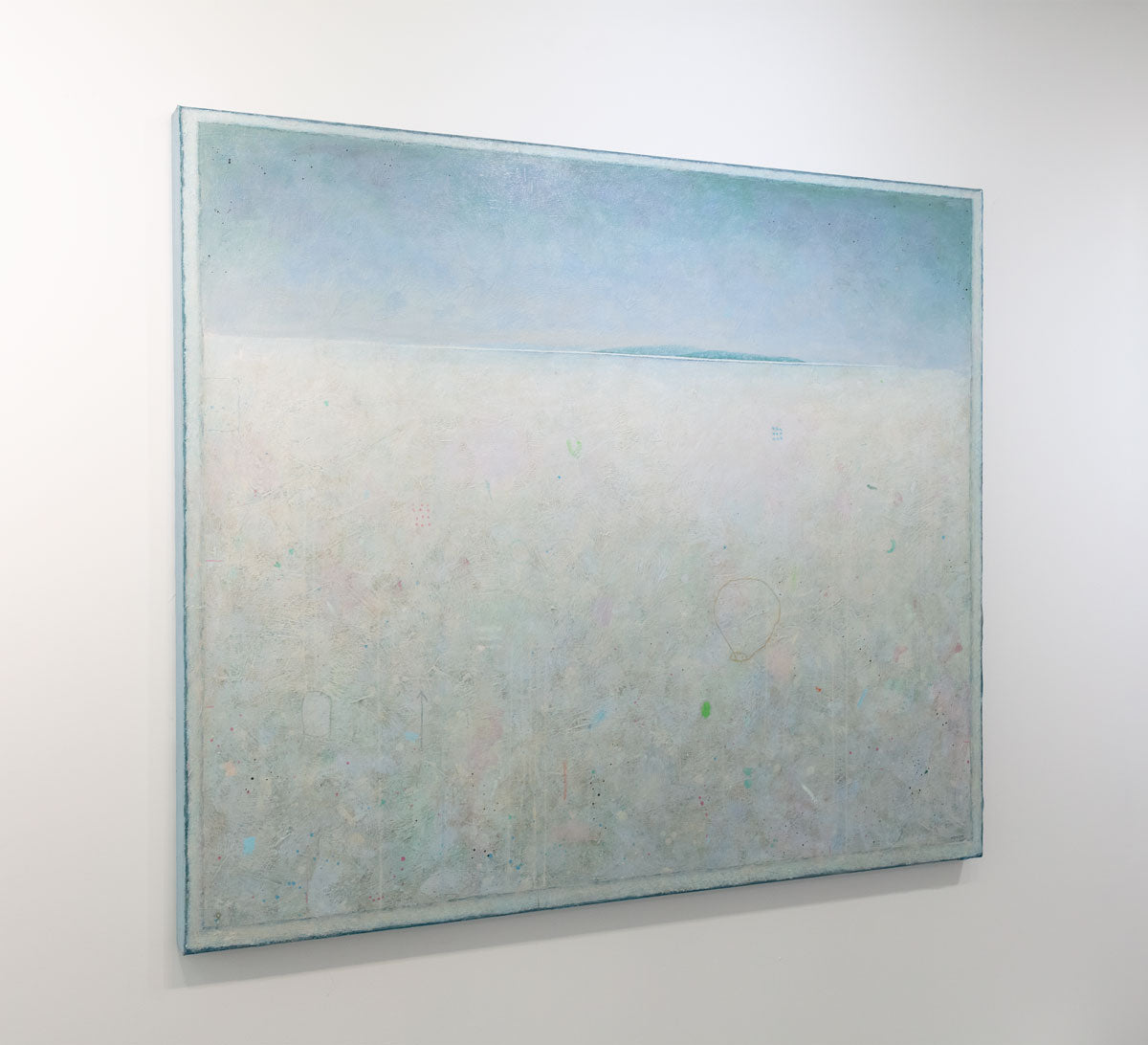 A left side-angle view of a white abstract landscape painting hangs on a white wall.