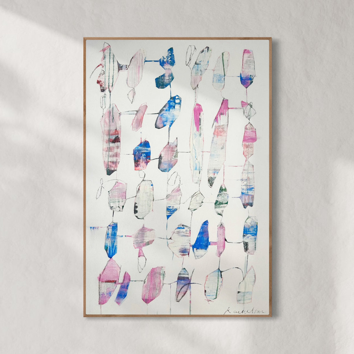 Abstract art print with colorful geometric shapes on a light gray wall.
