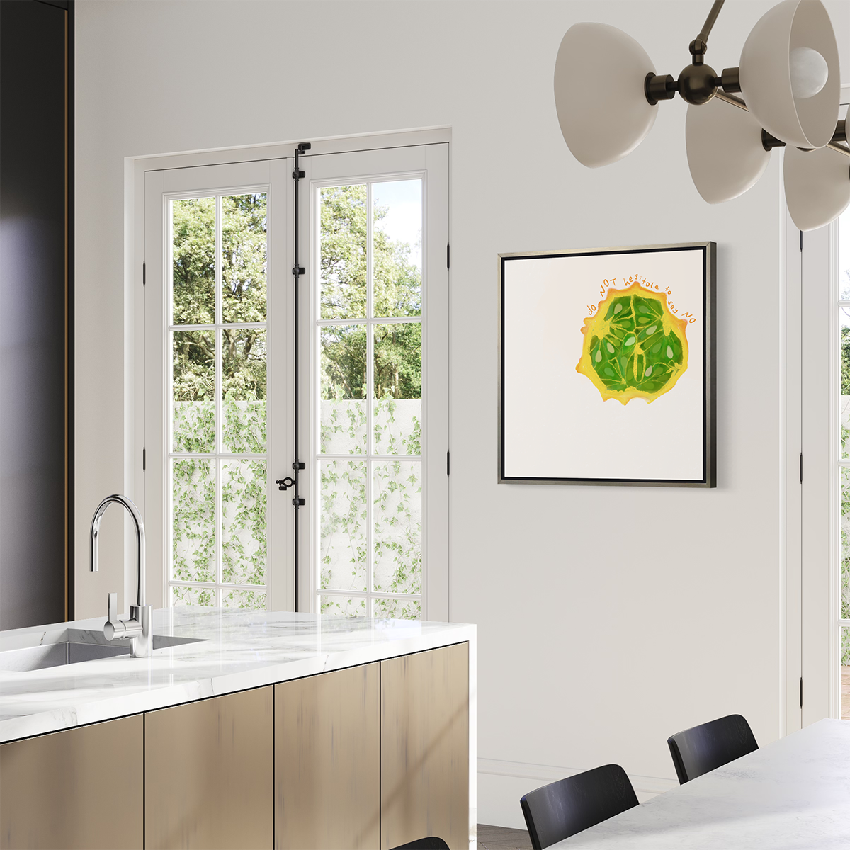 A side view of an abstract print of a fruit framed in a silver floater frame hangs on a white half wall above a white marble kitchen island with a sink.