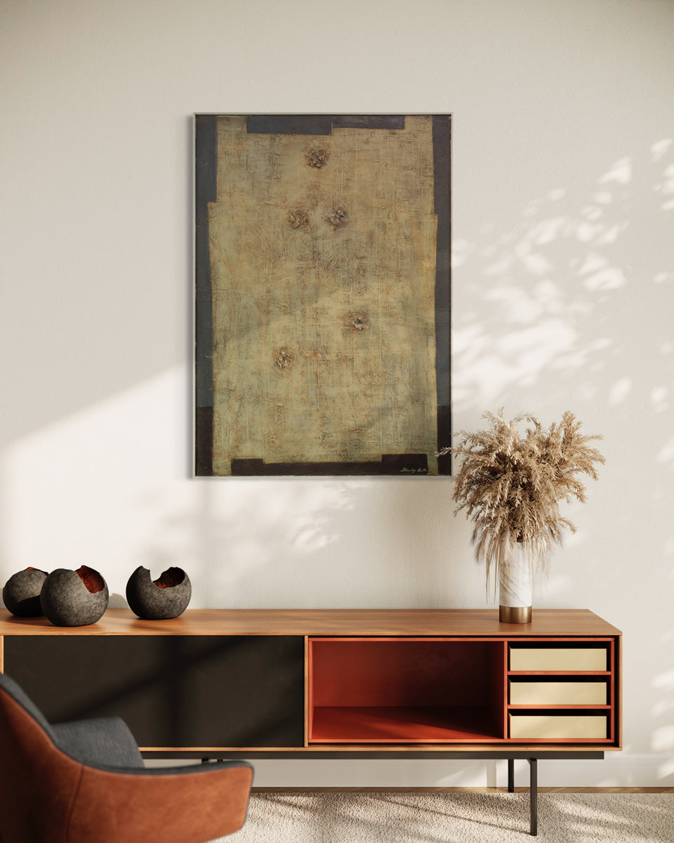 A modern abstract painting hangs on a white wall above a modern wood console table with modern table decor and an orange armchair. 