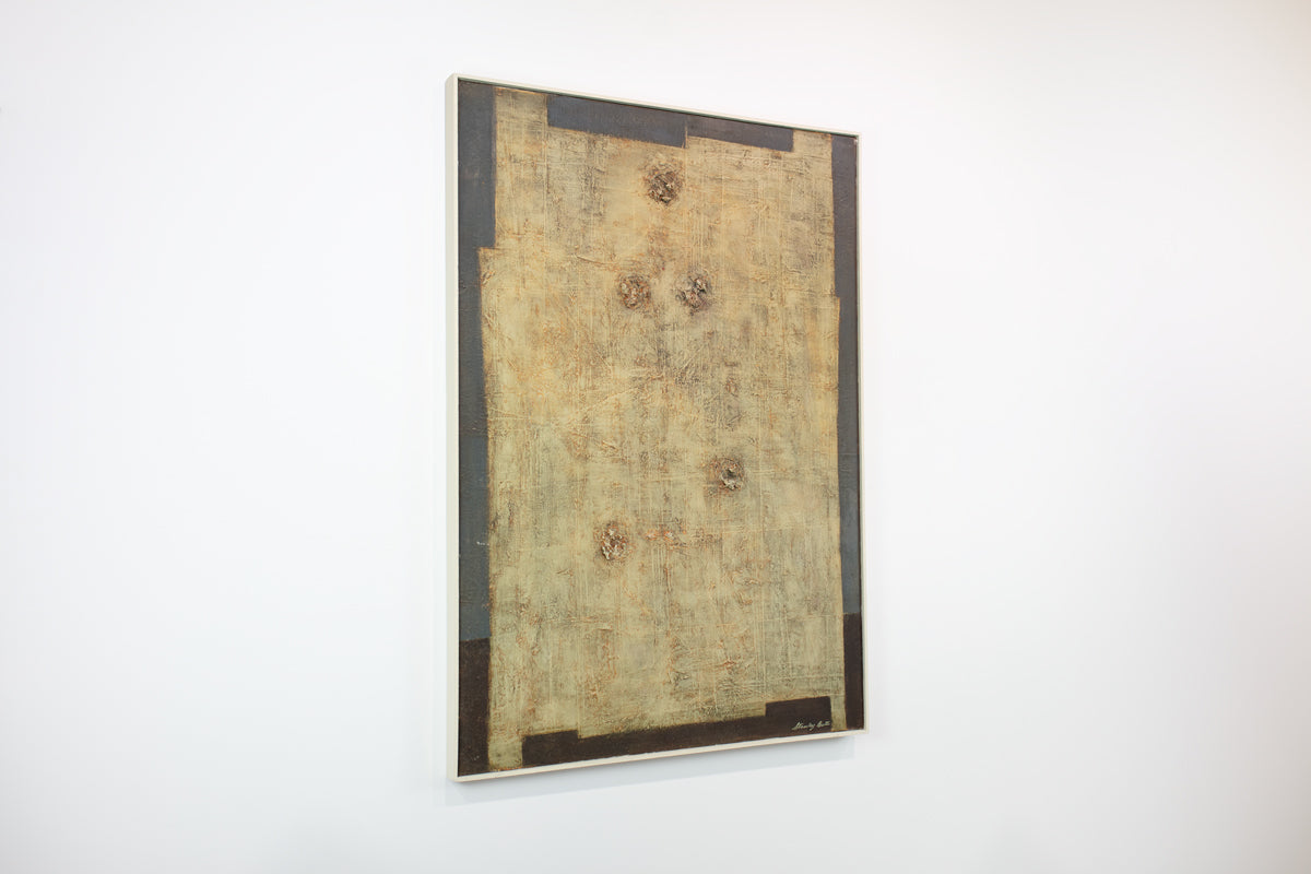 A grey and yellow-beige abstract painting hangs on a white wall.