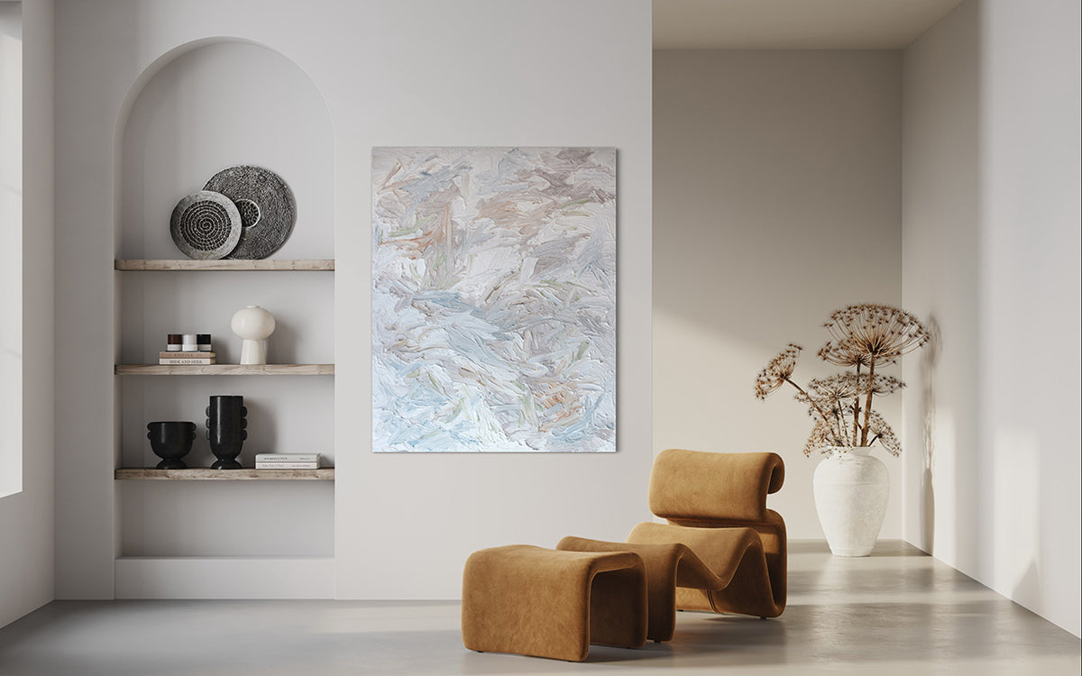 An abstract painting with thickly textured brushstrokes of beige, green, orange, and blue is hung in a family room.
